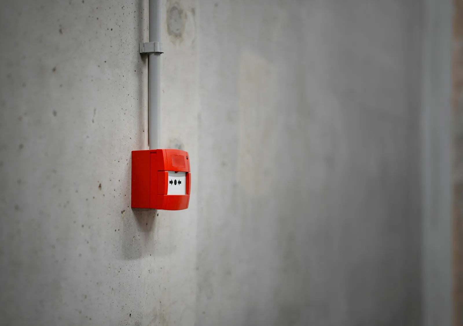 Roter Handfeuermelder an einer Betonwand